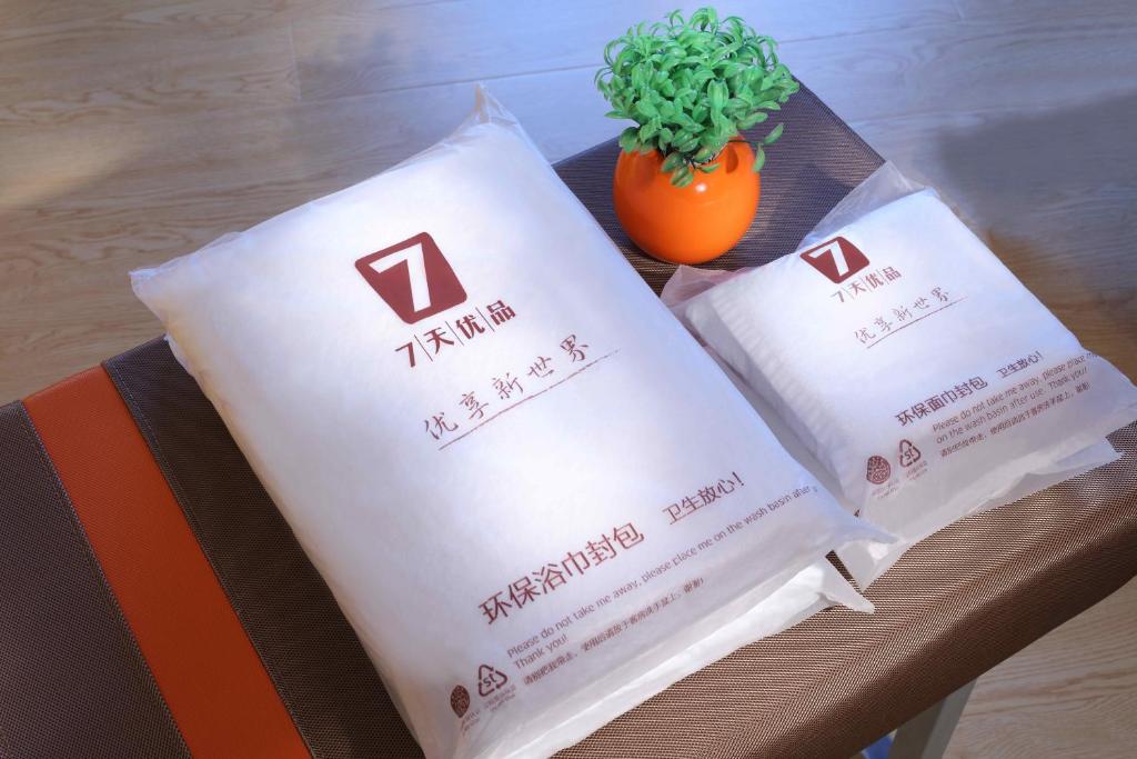 北京7天优品·北京鼓楼后海店的几袋装袋与植物坐在桌子上