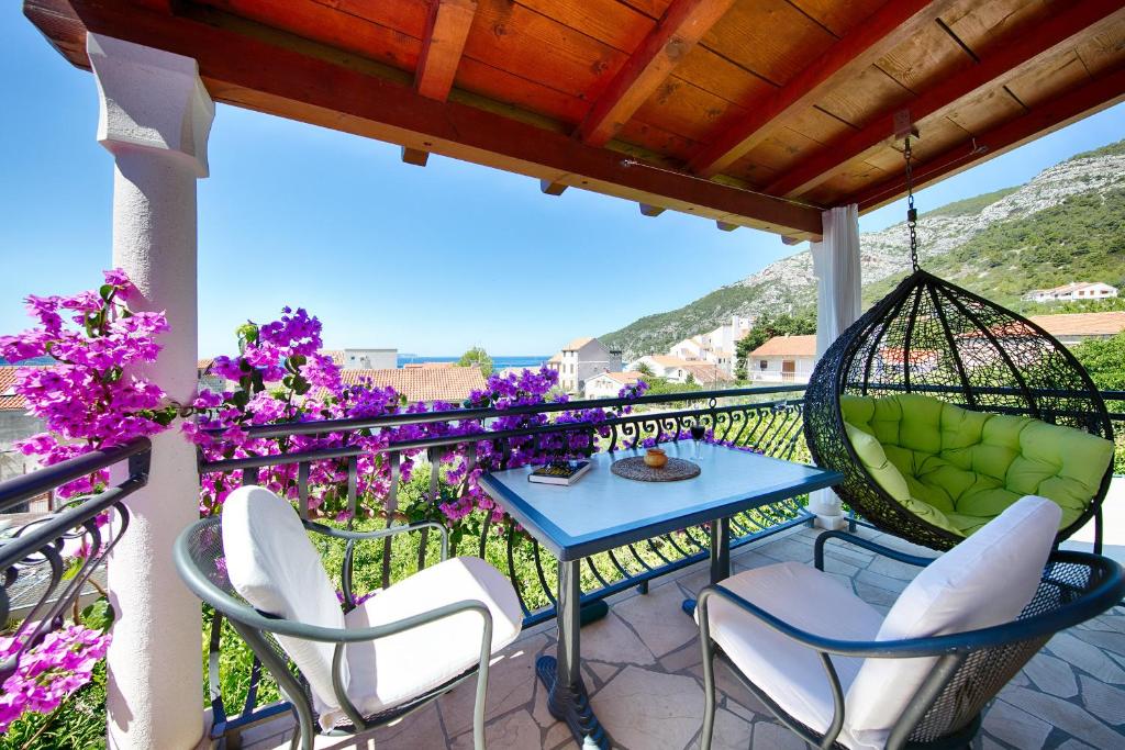 科米扎卡梅尼卡别墅 的庭院配有桌椅和紫色鲜花