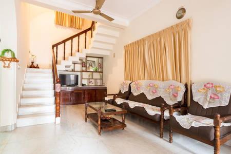 科钦Stay at DBRA 61 Don Bosco Cross Road Vaduthala Ernakulam的带沙发和楼梯的客厅