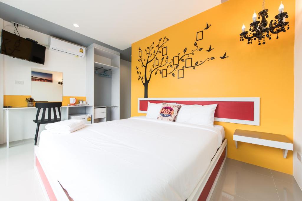 奈扬海滩慢生活海滩旅馆的卧室配有一张床铺,墙上挂有音乐音符