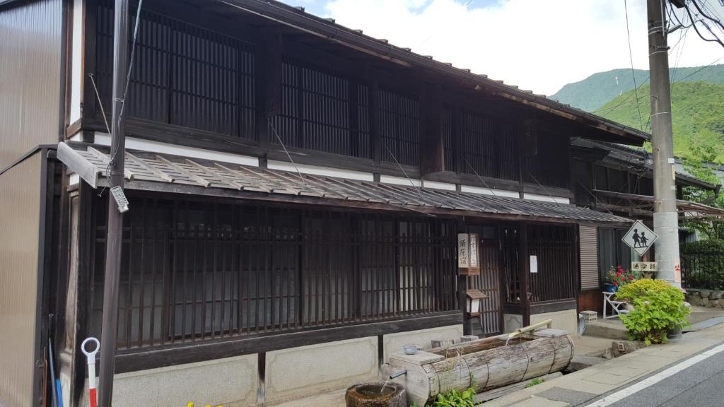 OkuwaMinshuku Suhara的一条在街上有黑窗的亚洲建筑
