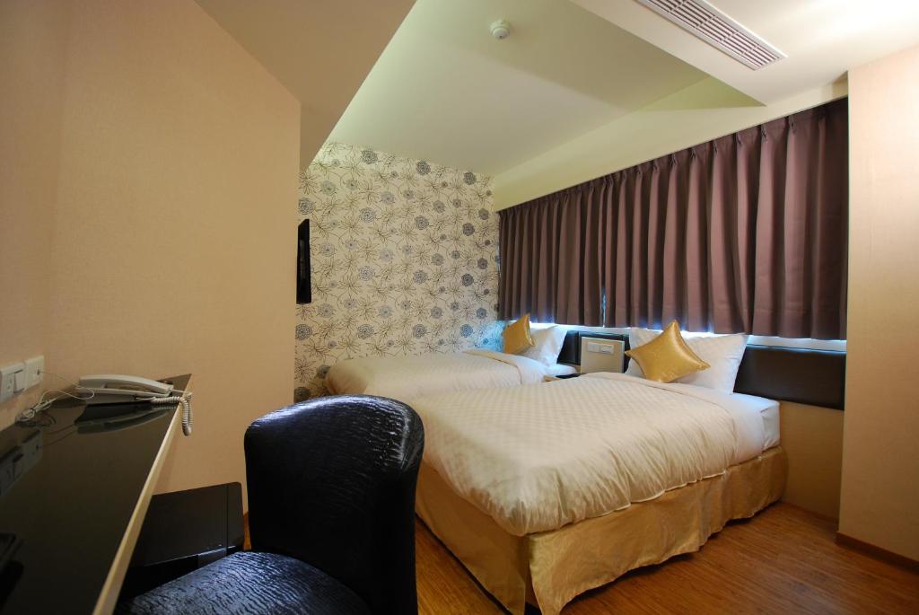 台北欣欣旅店的酒店客房配有两张床和一张书桌