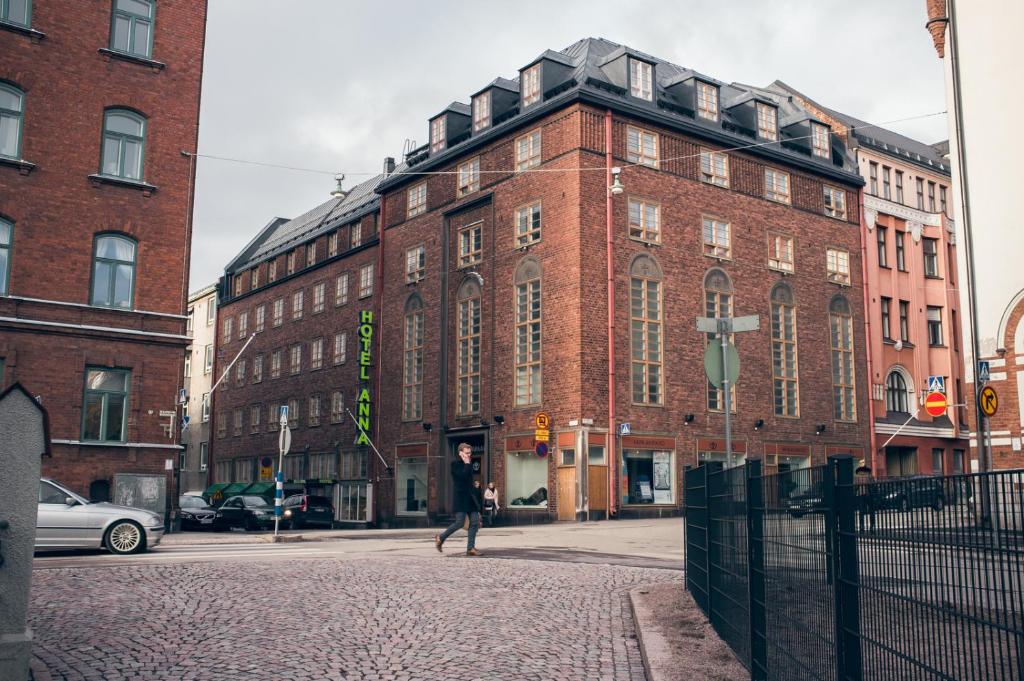 赫尔辛基安娜酒店的站在砖楼前走的人