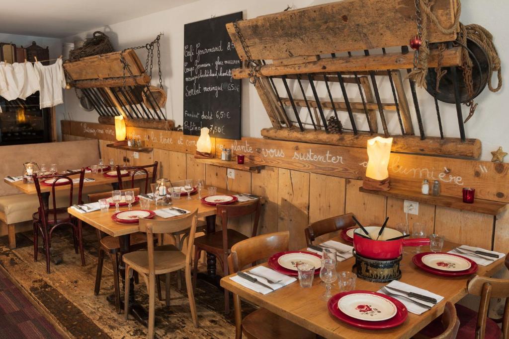 莱鲁斯Hôtel Restaurant La Ferme du Père François的一间带木桌和椅子以及黑板的餐厅