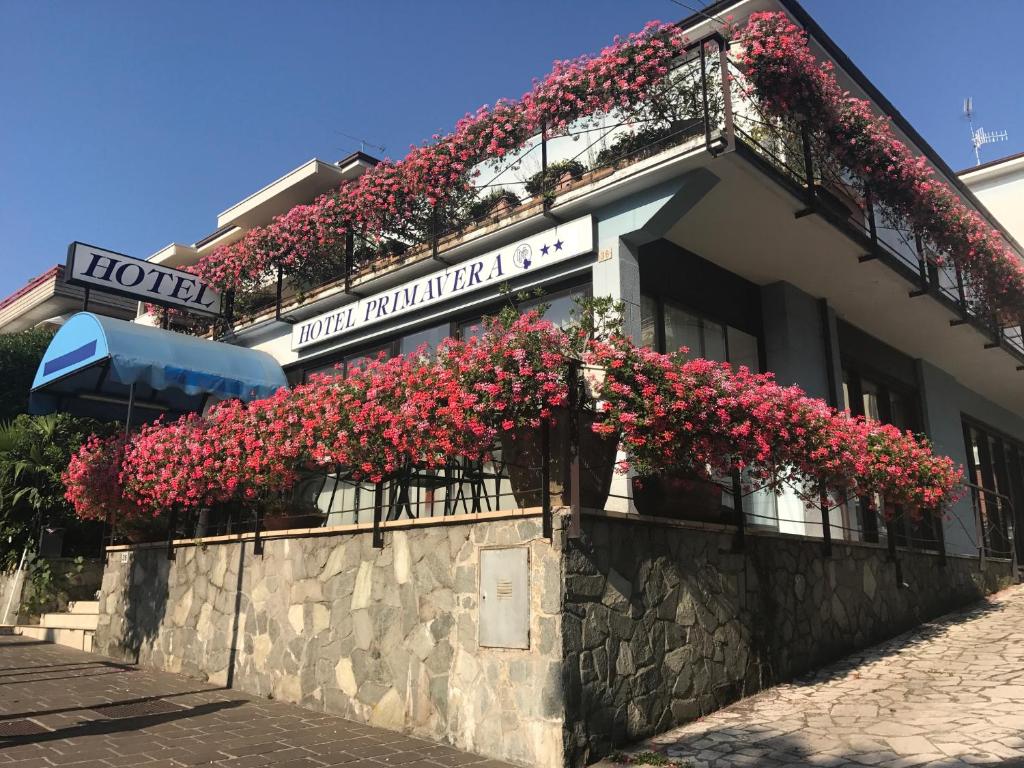 代森扎诺-德尔加达普里马维拉酒店的一座建筑的侧面是红花