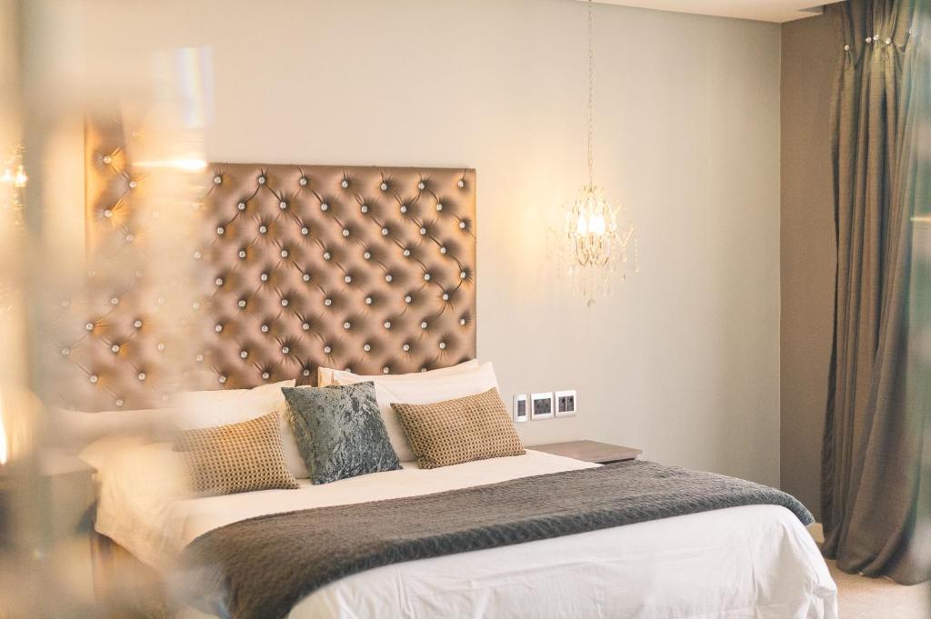 比勒陀利亚蓝钻精品酒店的一间卧室配有一张大床和一个吊灯。