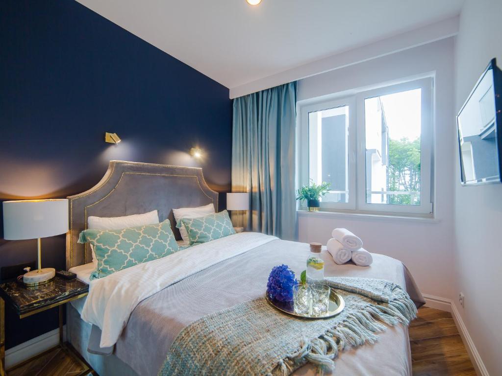 尤斯托尼莫斯基Apartament DWIE SOSNY的一间卧室设有一张大床和一个窗户。