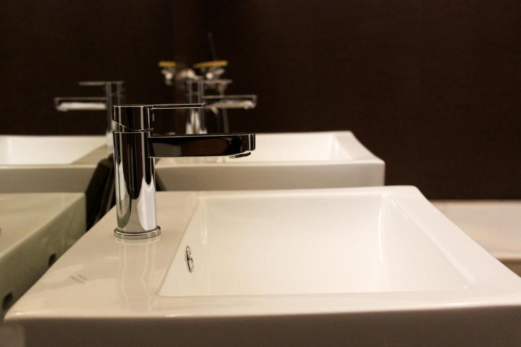迪马普尔Hotel Grand Tizu的浴室设有白色水槽和两面水龙头