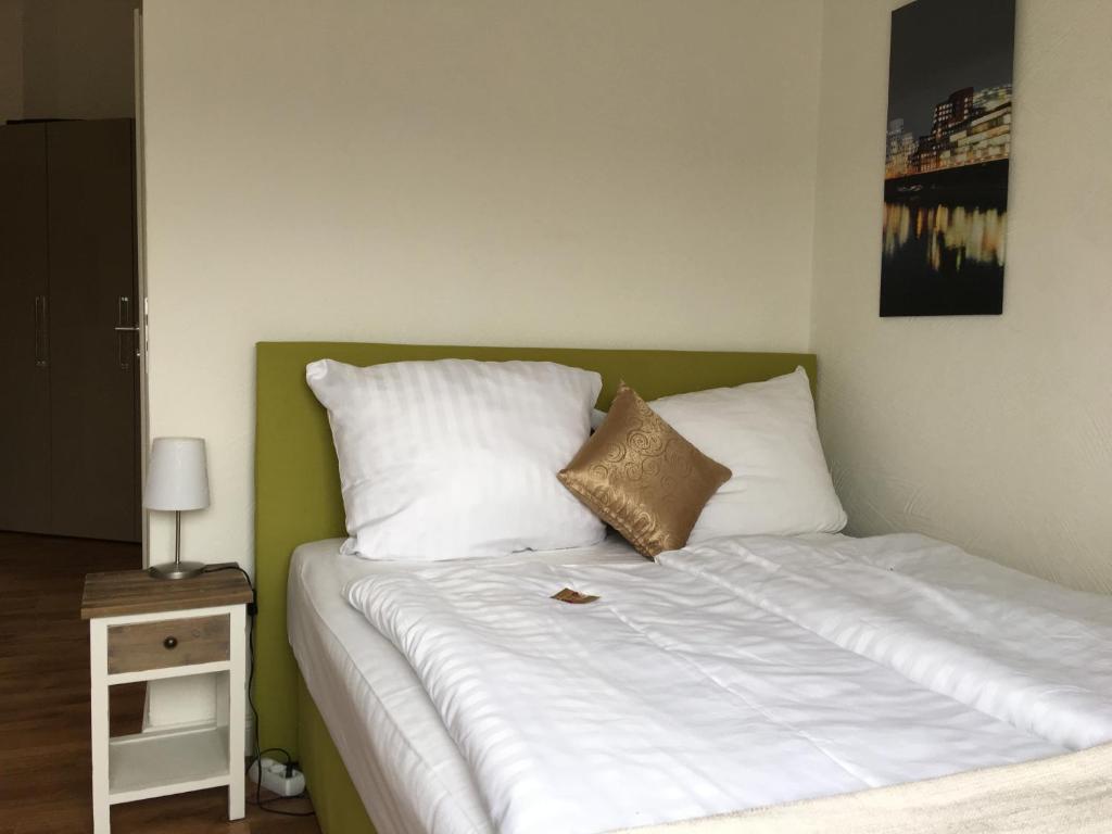 杜塞尔多夫Studiotel Belle Etage的一间卧室配有带白色枕头的床和床头柜