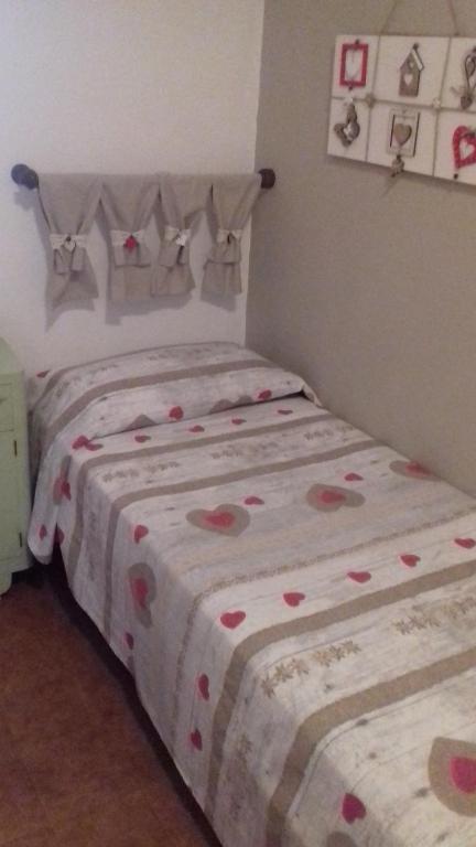 马利亚诺因托斯卡纳Agriturismo La Carlina的一间卧室配有两张床,床单上备有心盘