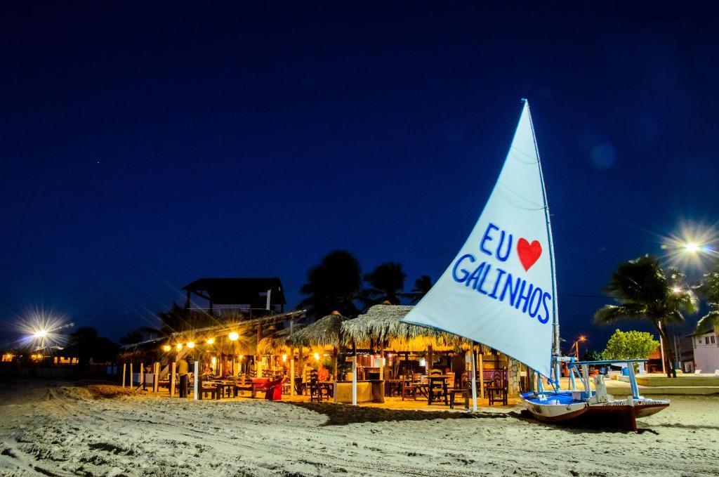 加利纽斯Pousada Brésil Aventure的夜间在海滩上乘坐帆船