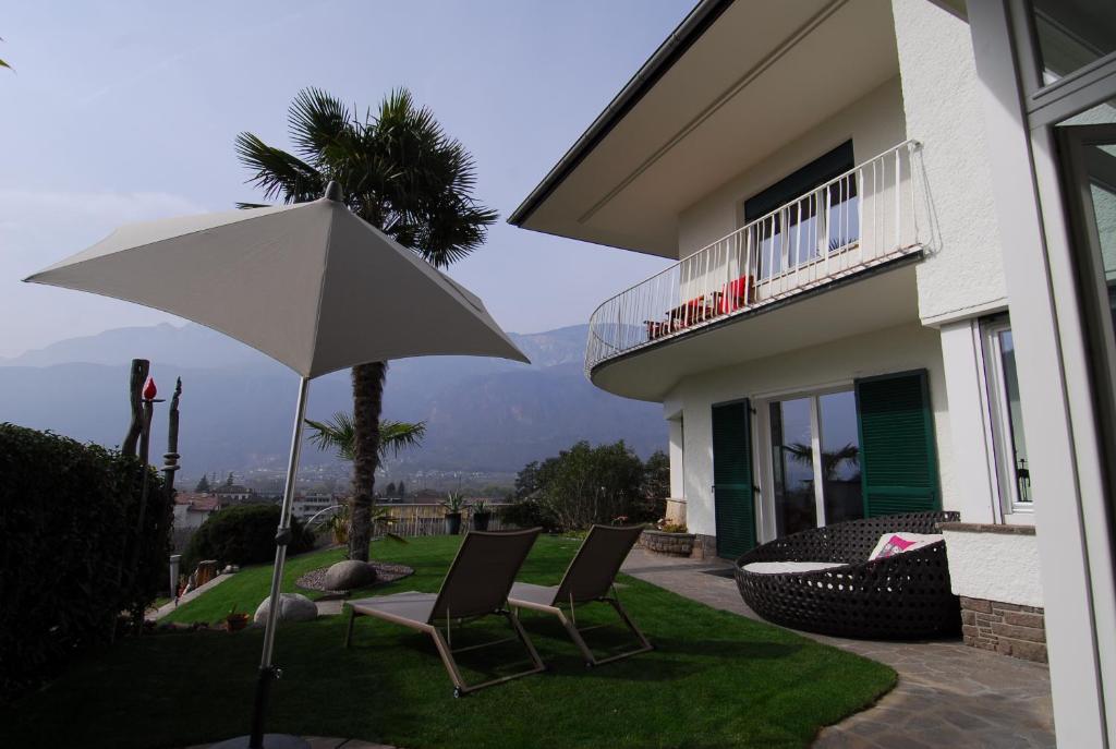 泰尔拉诺Torilan的房屋前设有带2把椅子和遮阳伞的天井。