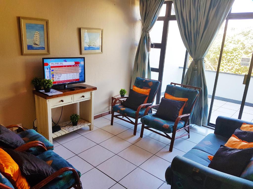 马盖特Dumela Margate Flat No 5的带沙发、电视和窗户的客厅