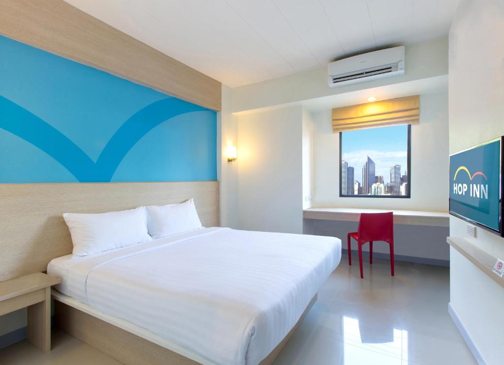 马尼拉Hop Inn Hotel Makati Avenue Manila的卧室配有白色的床和红色椅子
