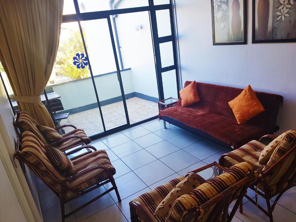 马盖特Dumela Margate Flat No 8的客厅配有红色的沙发和椅子
