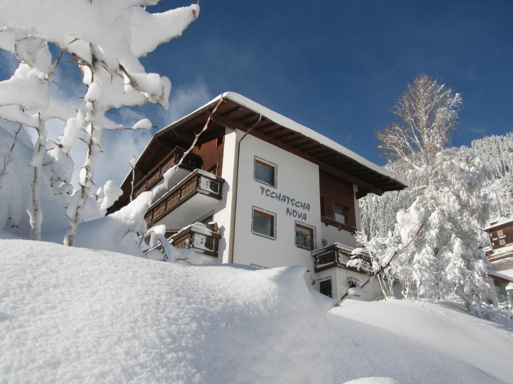 卡普尔提斯奇特诺亚酒店的一堆积雪旁的积雪覆盖的建筑物