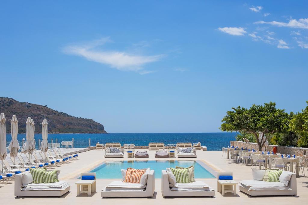 卡拉沃斯塔西翁波尔图精品酒店的一个带游泳池和椅子的度假胜地和大海