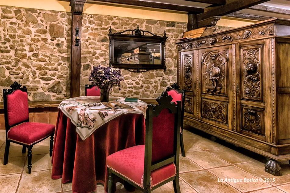 帕萨若La Antigua Botica的用餐室配有红色椅子和木柜