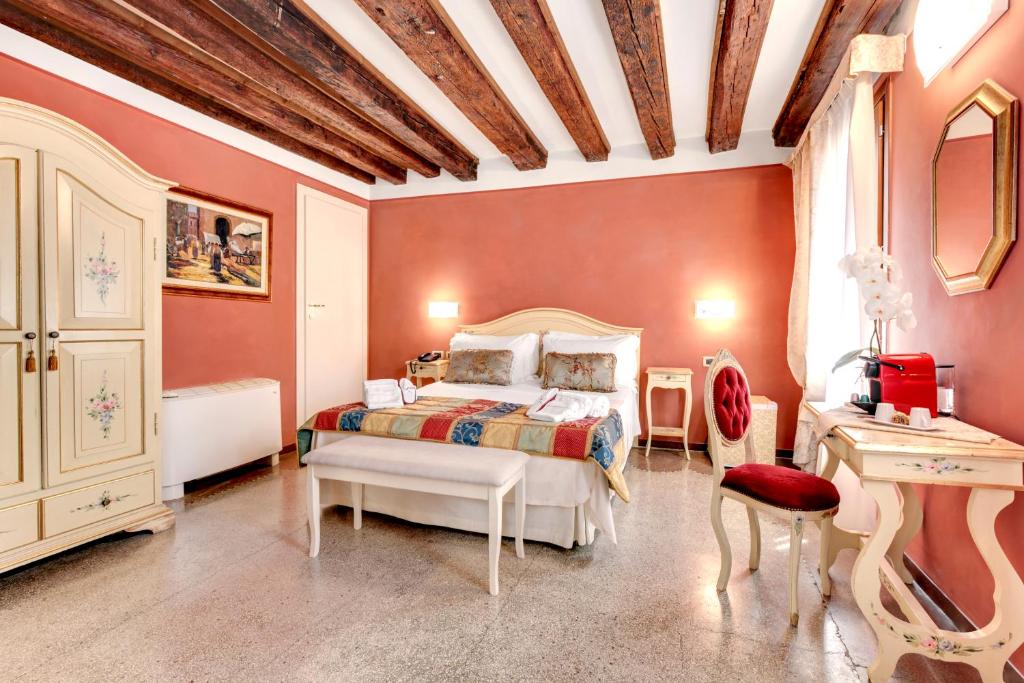 威尼斯卡里萨旅馆的一间卧室配有一张床、一张桌子和一张书桌