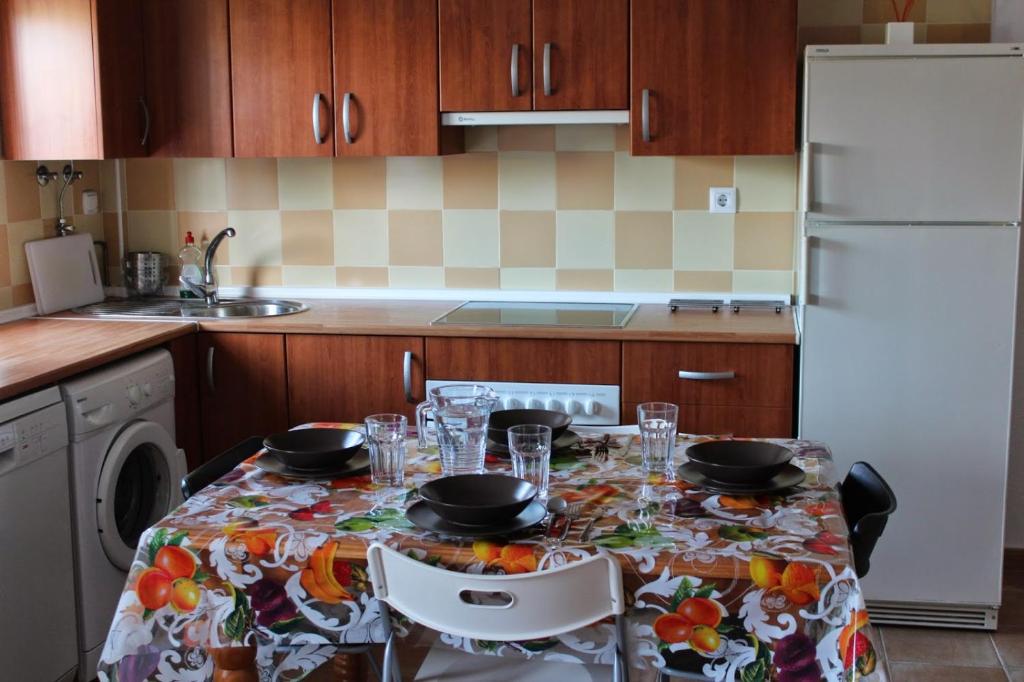 罗塔Apartment in Rota Cadiz, Air Cond, Wifi, Patio的厨房配有带盘子和玻璃杯的桌子