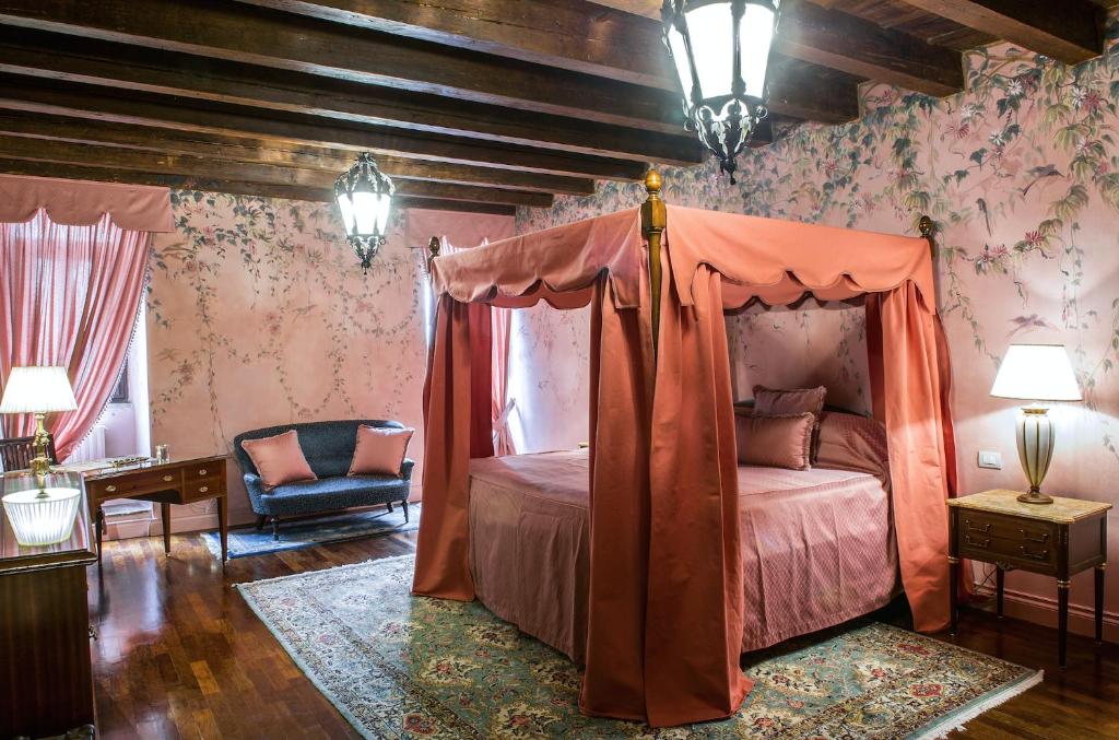 维罗纳Casa Borsari Suite的一间卧室配有一张天蓬床和一把椅子