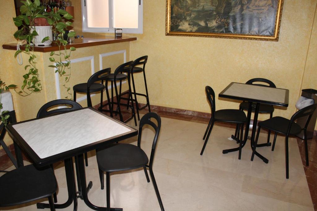 圣地亚哥德拉里贝拉Hotel Albohera的一套桌子和椅子