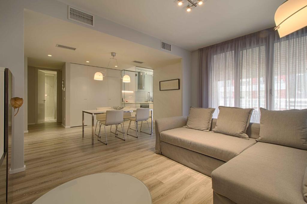 地拉那The Rooms Serviced Apartments Nobis Complex的客厅配有沙发和桌子