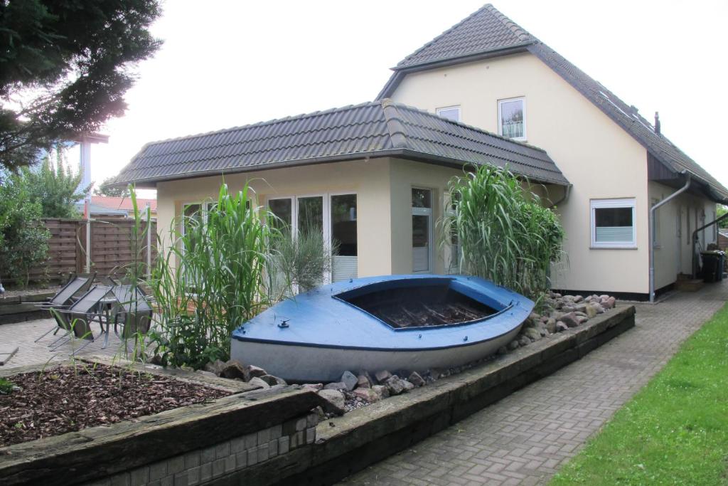 HirschburgFerienwohnung Ostseenähe的坐在房子前面的蓝色小船