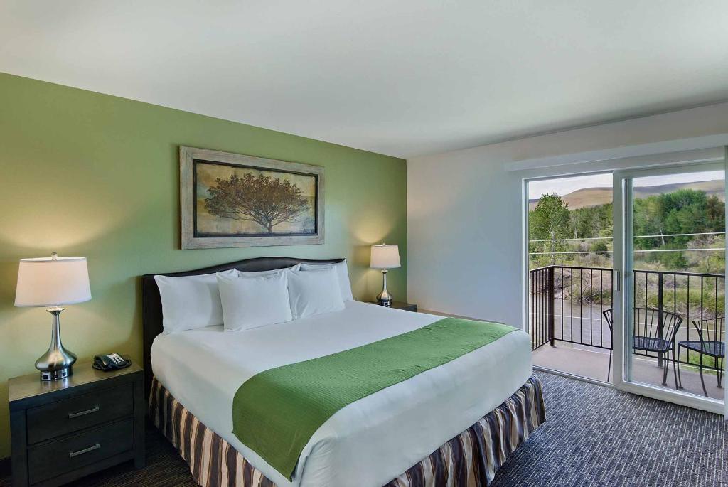 亚基马亚基马牛津套房酒店的一间带大床的卧室和一个阳台