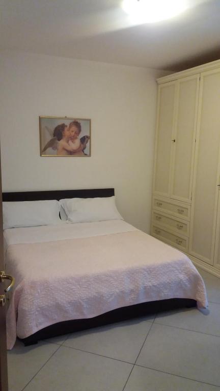 萨沃纳Bilocale nell'antica darsena的卧室配有白色的床和墙上的绘画作品