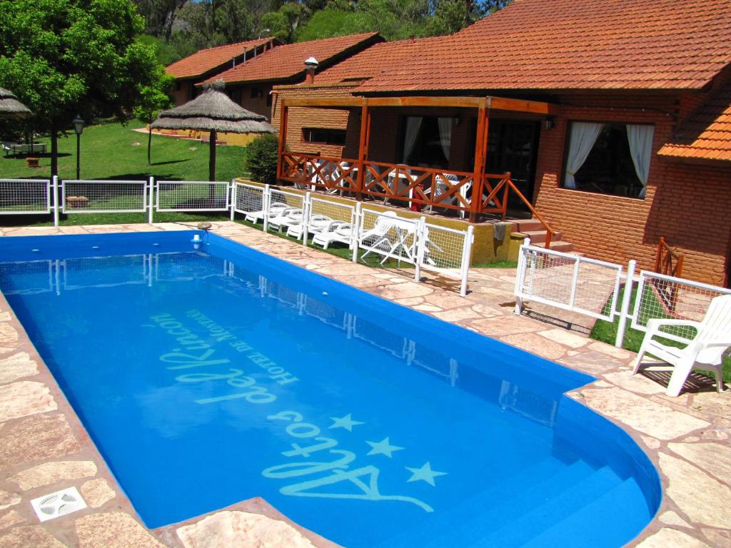 梅洛Hotel Altos del Rincon的一座大蓝色游泳池,位于房子前