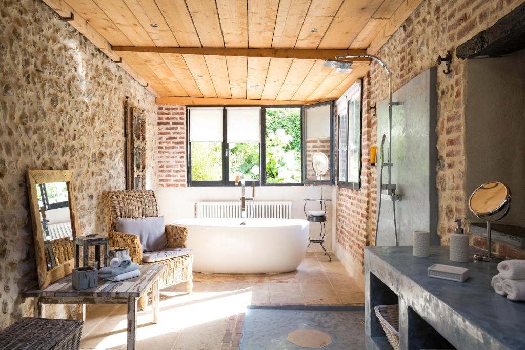 翁弗勒尔公园之家住宿加早餐旅馆的一间带浴缸的浴室,位于一间砖墙客房内