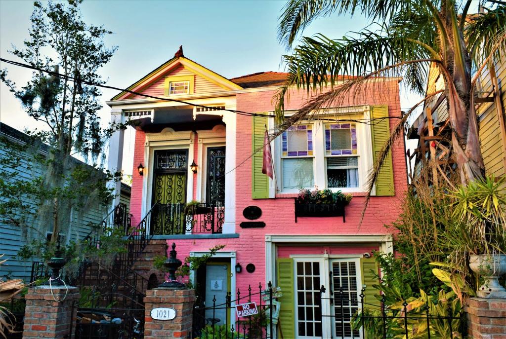 新奥尔良Madame Isabelle's House的粉红色和黄色的房子设有阳台