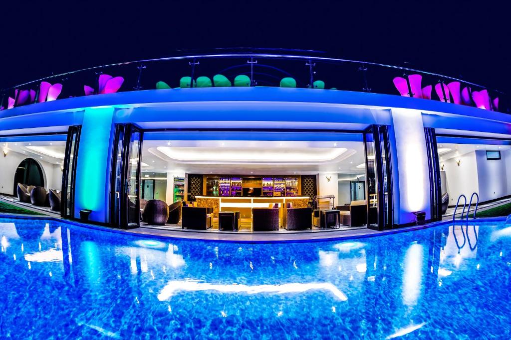 洞海皇家广平酒店 的一座大楼中央的游泳池,里面设有酒吧