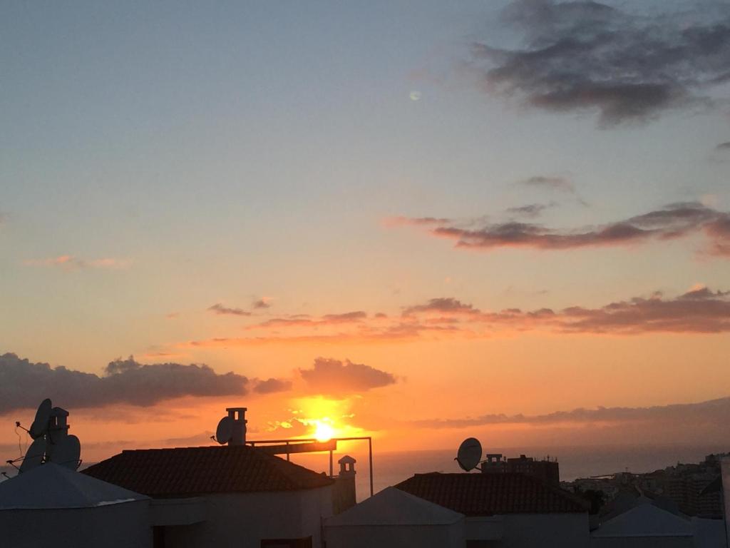 洛斯克里斯蒂亚诺斯Porto Royale的日落在建筑屋顶上,有太阳