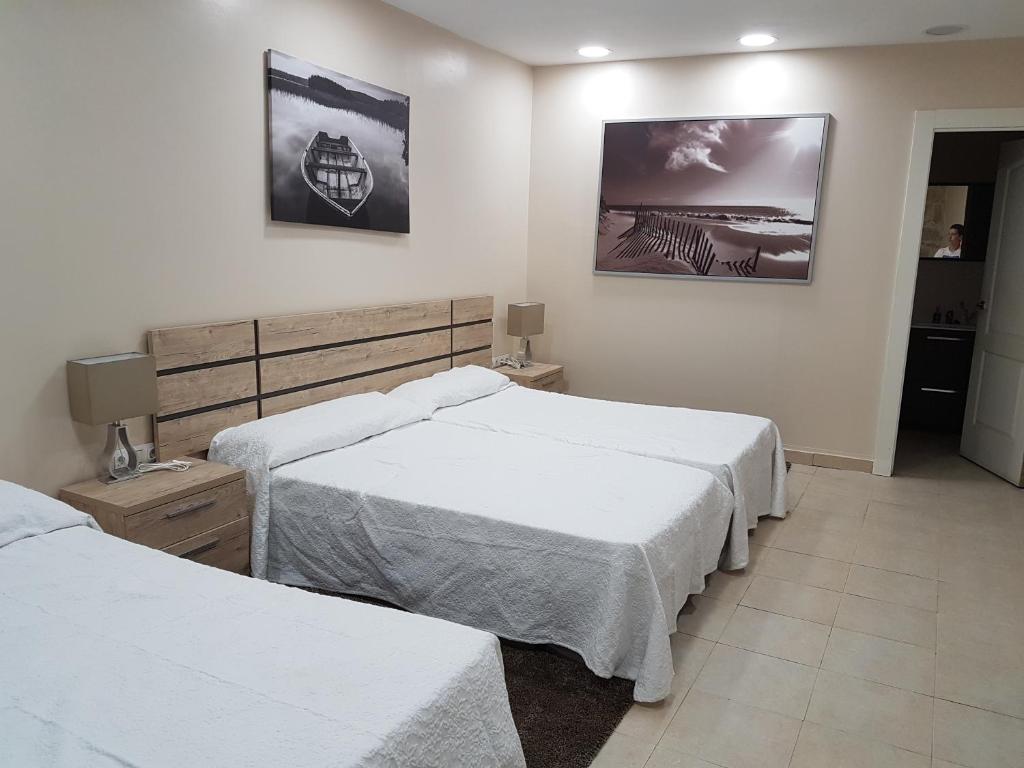 科巴罗港口之家酒店的卧室配有两张床,墙上挂有两张照片