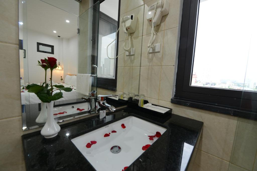 河内河内布鲁城市酒店的浴室配有带红玫瑰的浴缸
