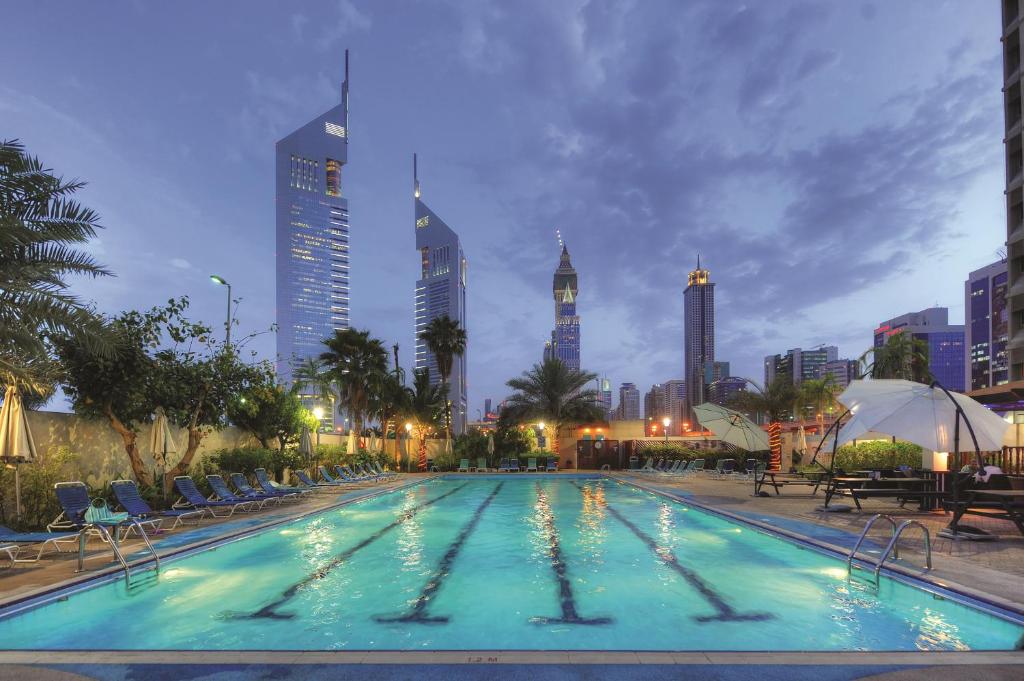 迪拜迪拜世界贸易中心公寓酒店的一座位于城市的游泳池,有高大的建筑