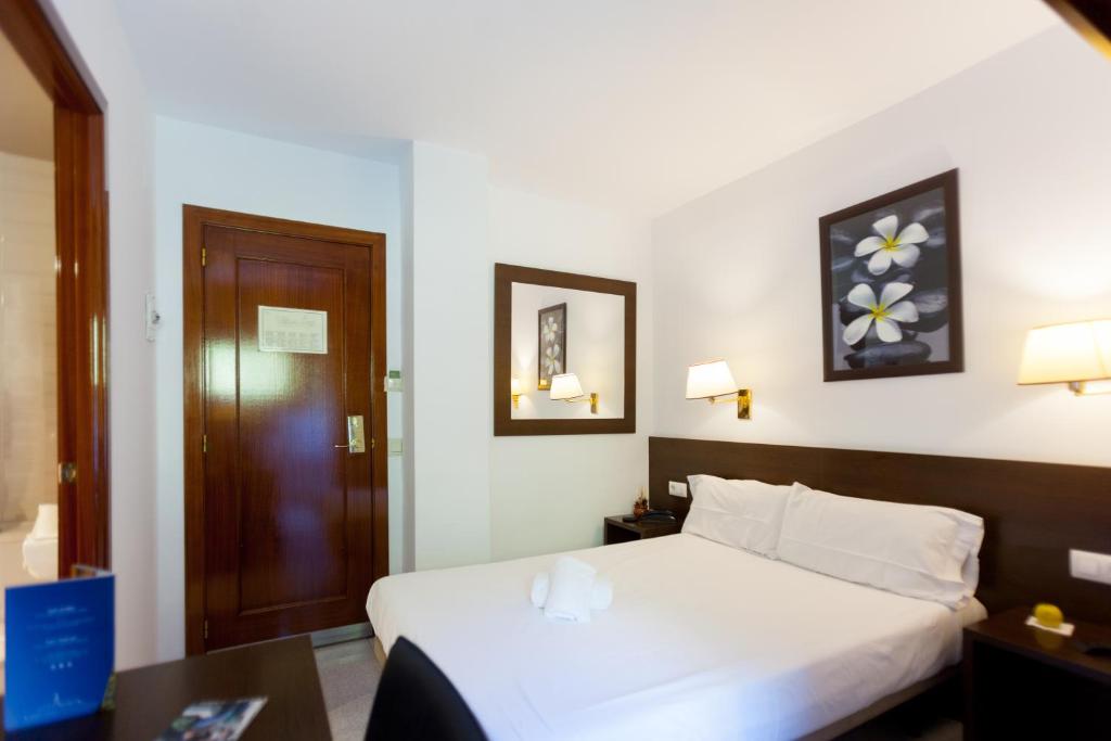 安道尔城Insitu Eurotel Andorra的卧室配有白色的床和木门