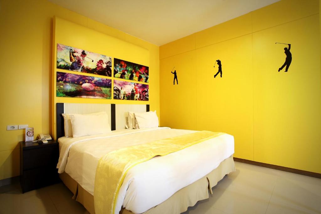 明古鲁省塞纳体育酒店的一间卧室配有一张床,墙上挂着一些图片