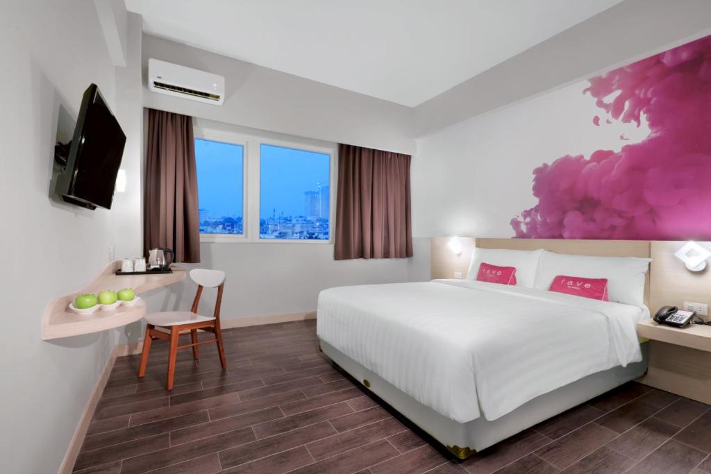 棉兰棉兰帕曼酒店的一间酒店客房,配有一张床和一台电视