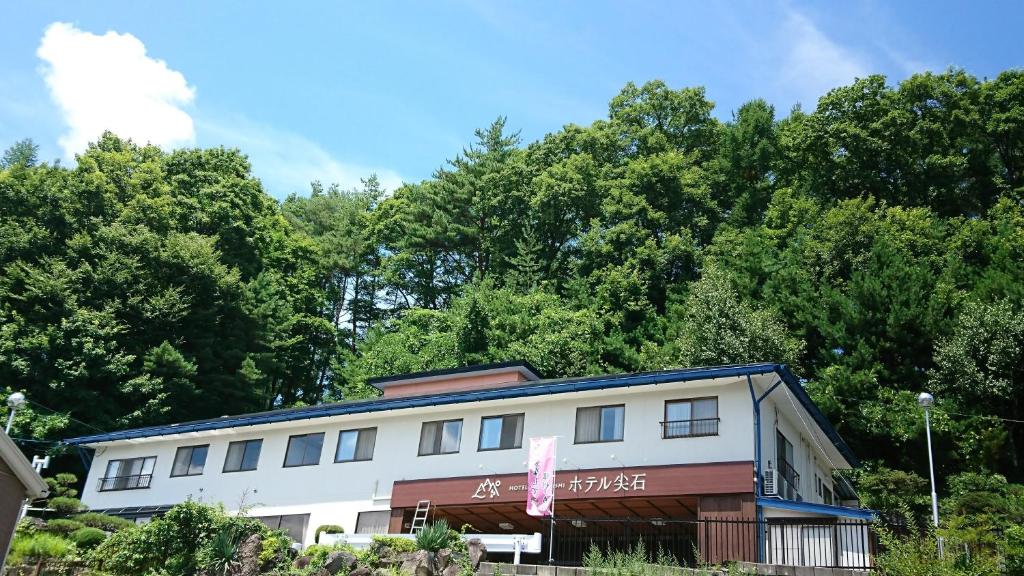 茅野多佳尼西酒店 的一座白楼,有树木背景
