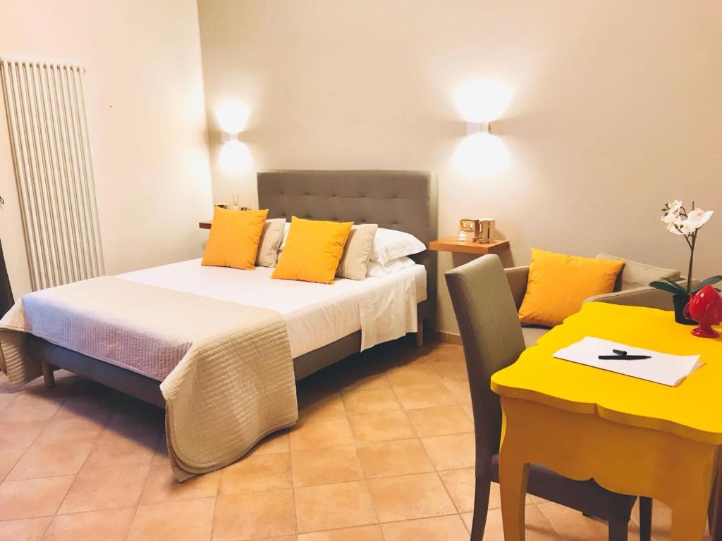 特拉尼A DUE PASSI temporary apartment的一间卧室配有一张带黄色枕头和桌子的床