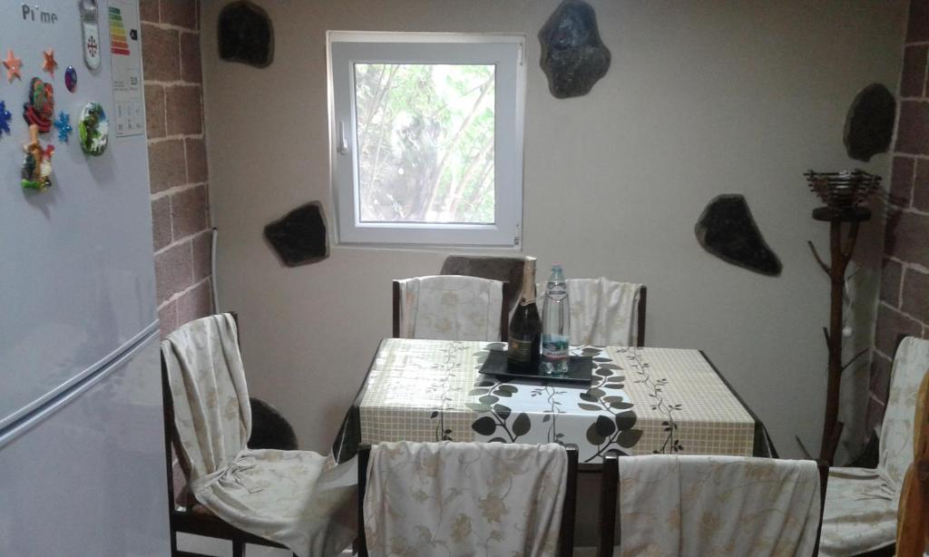 博尔若米Guest House Nima的一间带桌椅和窗户的用餐室