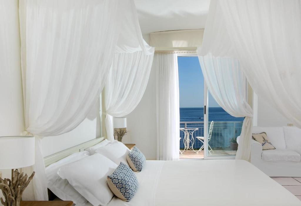 马奥莱都耶托丽俱乐部酒店的白色的卧室设有床和大窗户