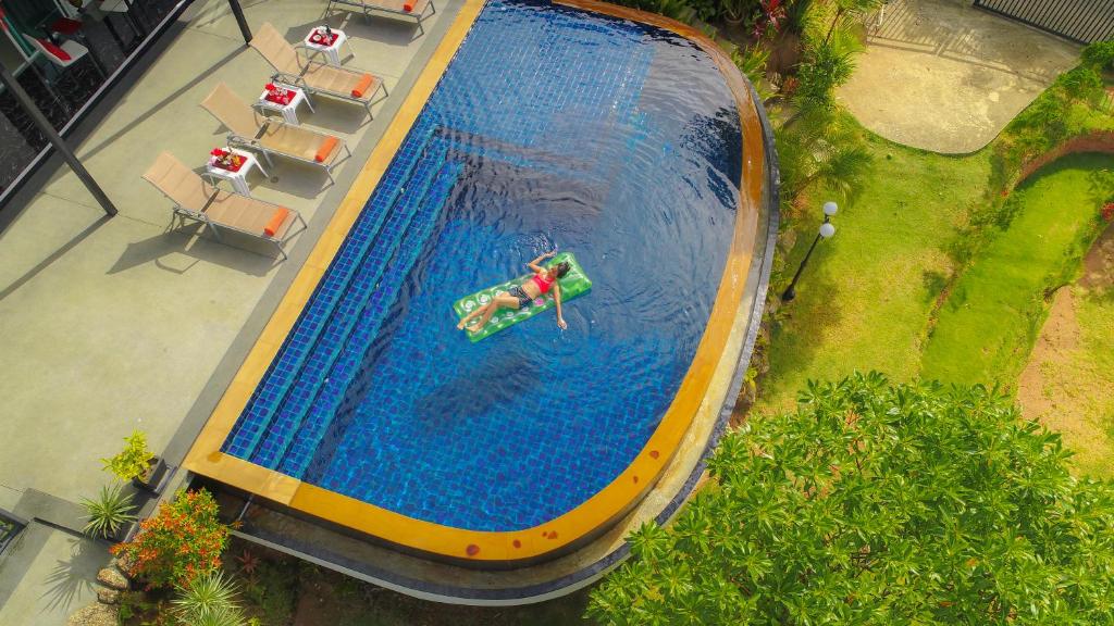 查龙Villa Nap Dau Crown - 8 Br Private Pool Villa - Chalong的游泳池的顶部景色,游泳池里的人