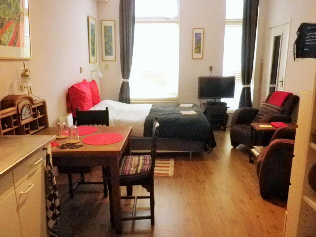 格罗宁根Appartement centrum Groningen的一个小客厅,配有一张床和一张桌子