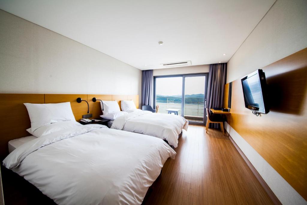 晋州市亚洲湖畔酒店的酒店客房设有三张床和电视。
