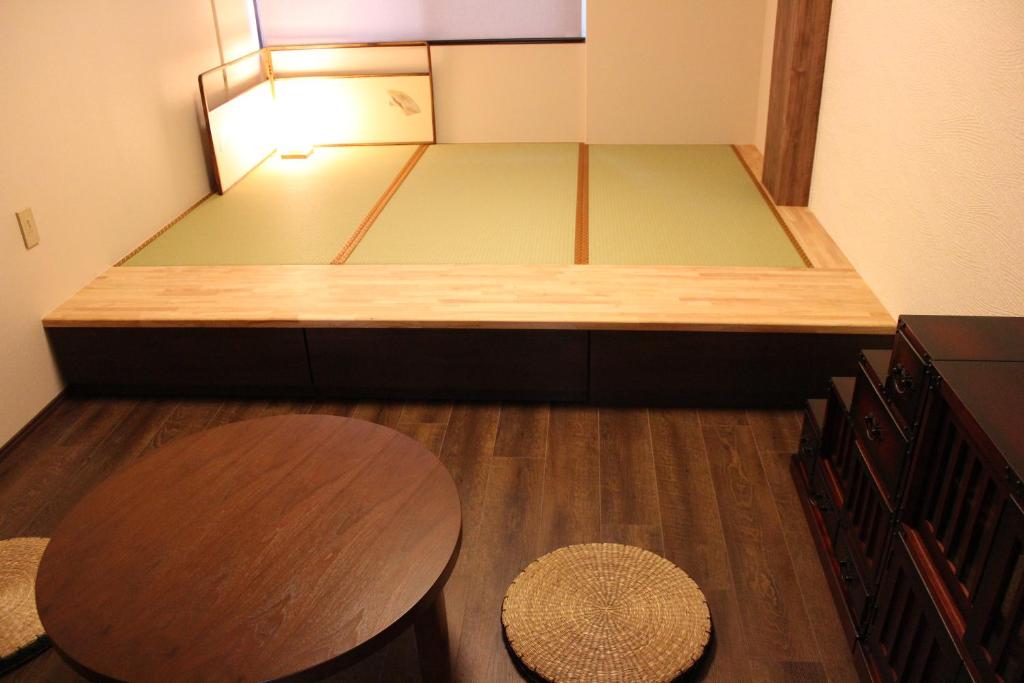 金泽阳光高地度假租赁酒店的小房间设有床、桌子和椅子