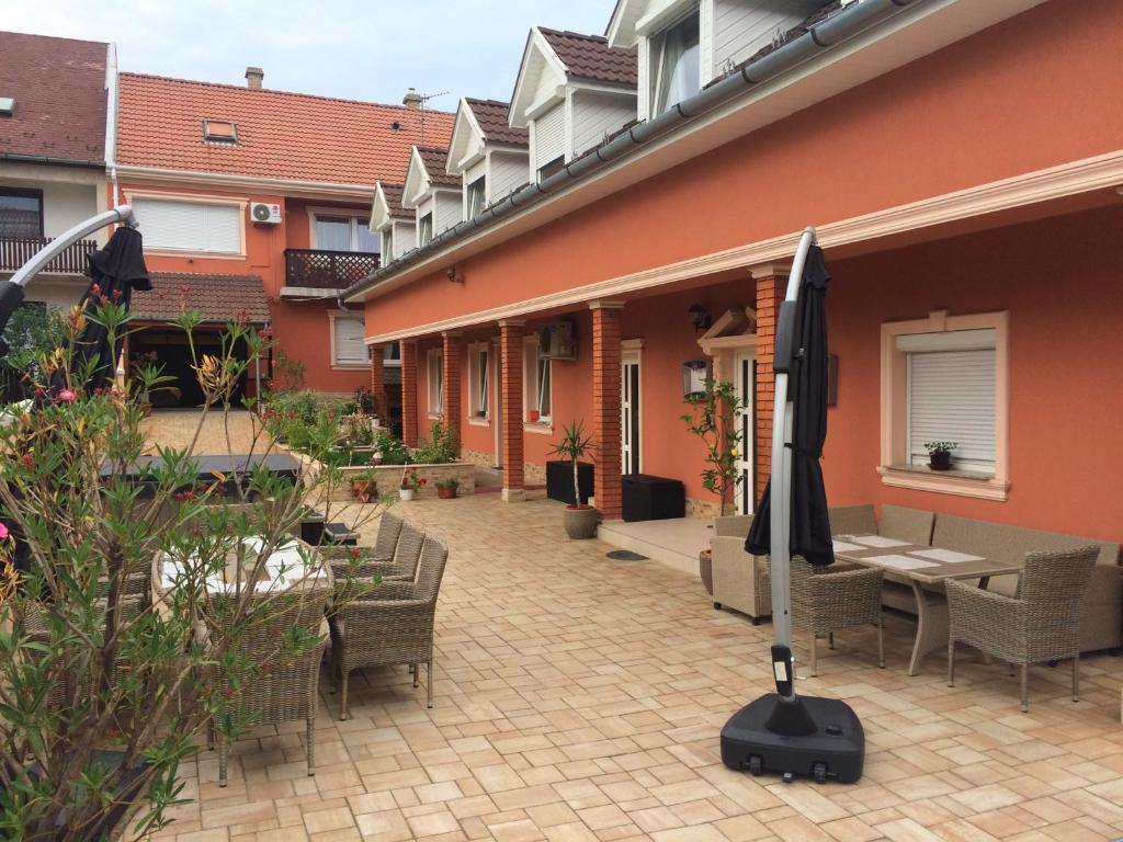 瓦茨星级旅馆的庭院配有桌椅和遮阳伞。